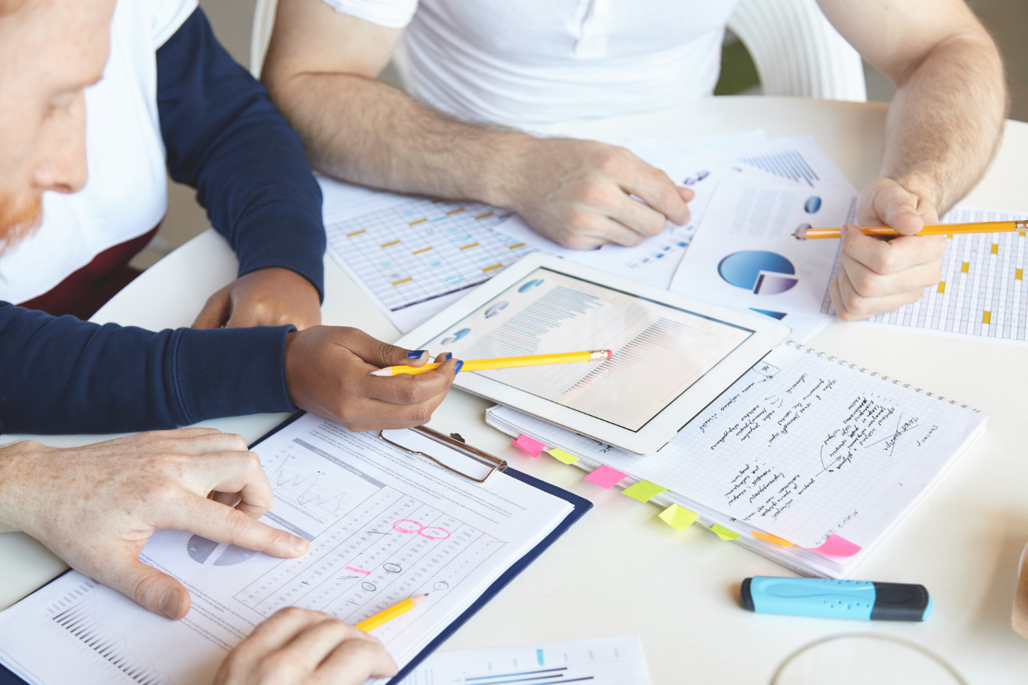 Team bei der Planung einer Content-Marketing-Strategie mit Tablet und Diagrammen. Unterstützung für Medizintechnik im Mittelstand durch das Textquartier Marius von der Forst.