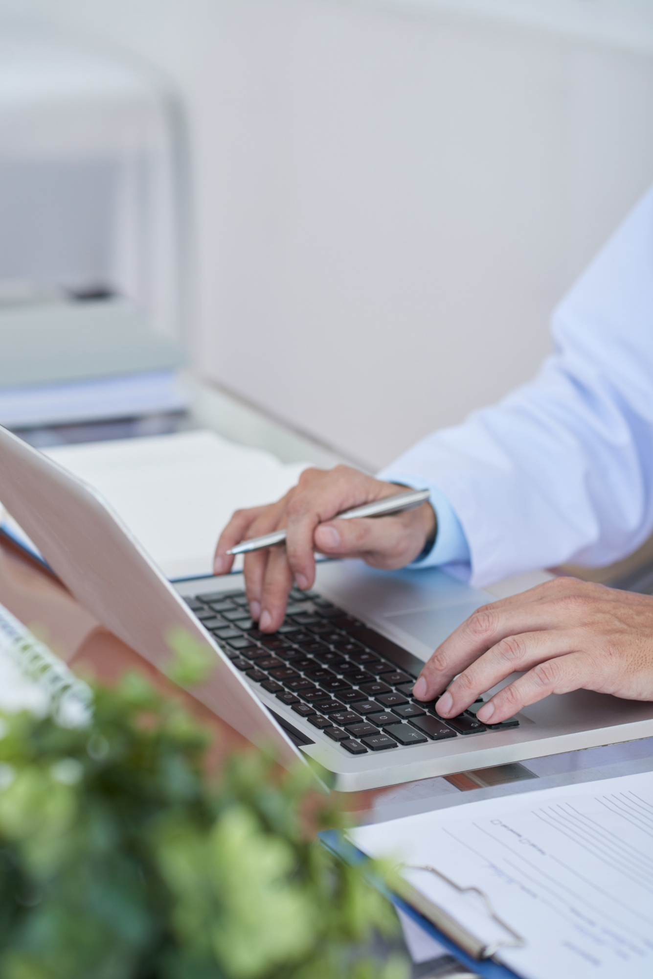 Hände einer medizinischen Fachkraft tippen am Laptop. E-E-A-T und YLYM im Gesundheitswesen. Blogartikel beim Textquartier Marius von der Forst.