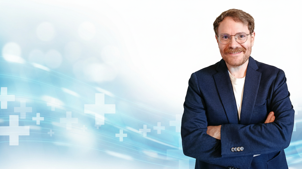 Marius von der Forst, Experte für E-Mail-Marketing und Inhaber vom Textquartier. Professionelles Porträt vor medizinischem Hintergrund.