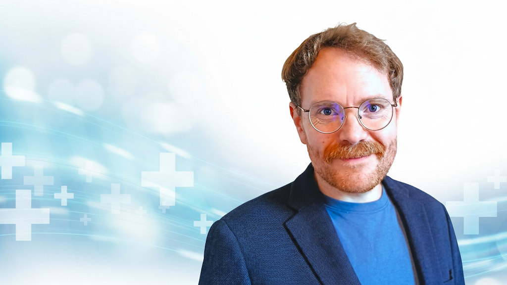 Marius von der Forst, Experte für Healthcare-Texte und Inhaber vom Textquartier. Professionelles Porträt vor medizinischem Hintergrund.