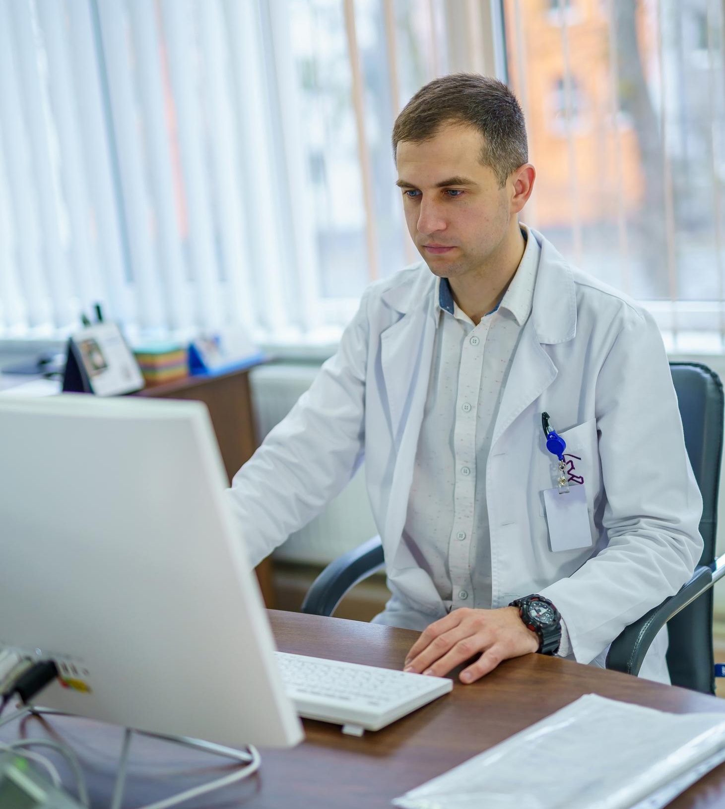 Arzt am Schreibtisch, der Patientengeschichten und Case Studys für verständliche Kommunikation auswertet Blogartikel beim Textquartier Marius von der Forst.
